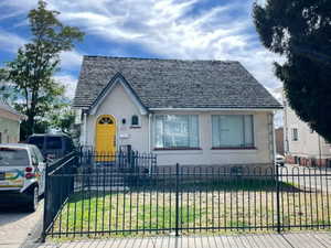 View of front of home with a fenced front yard and stucco siding