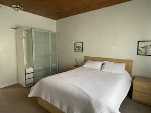 Carpeted bedroom with wooden ceiling