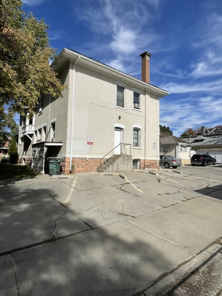 View of building exterior with uncovered parking