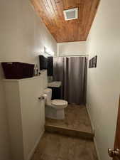 Bathroom with wood ceiling and curtained shower