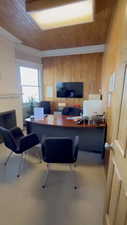 Office featuring wood walls, a fireplace, and wood ceiling