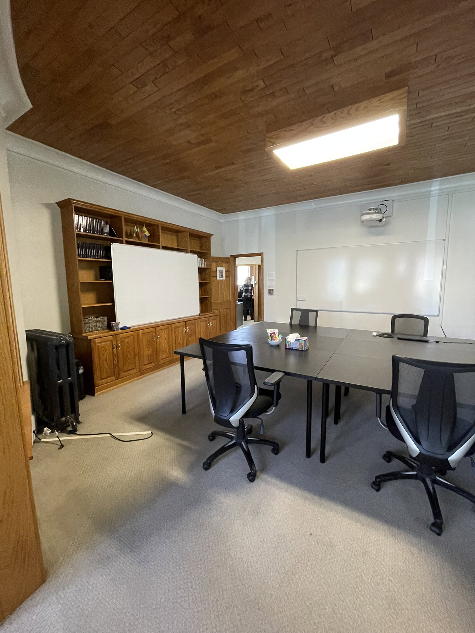 Home office with light colored carpet, wooden ceiling, ornamental molding, and radiator