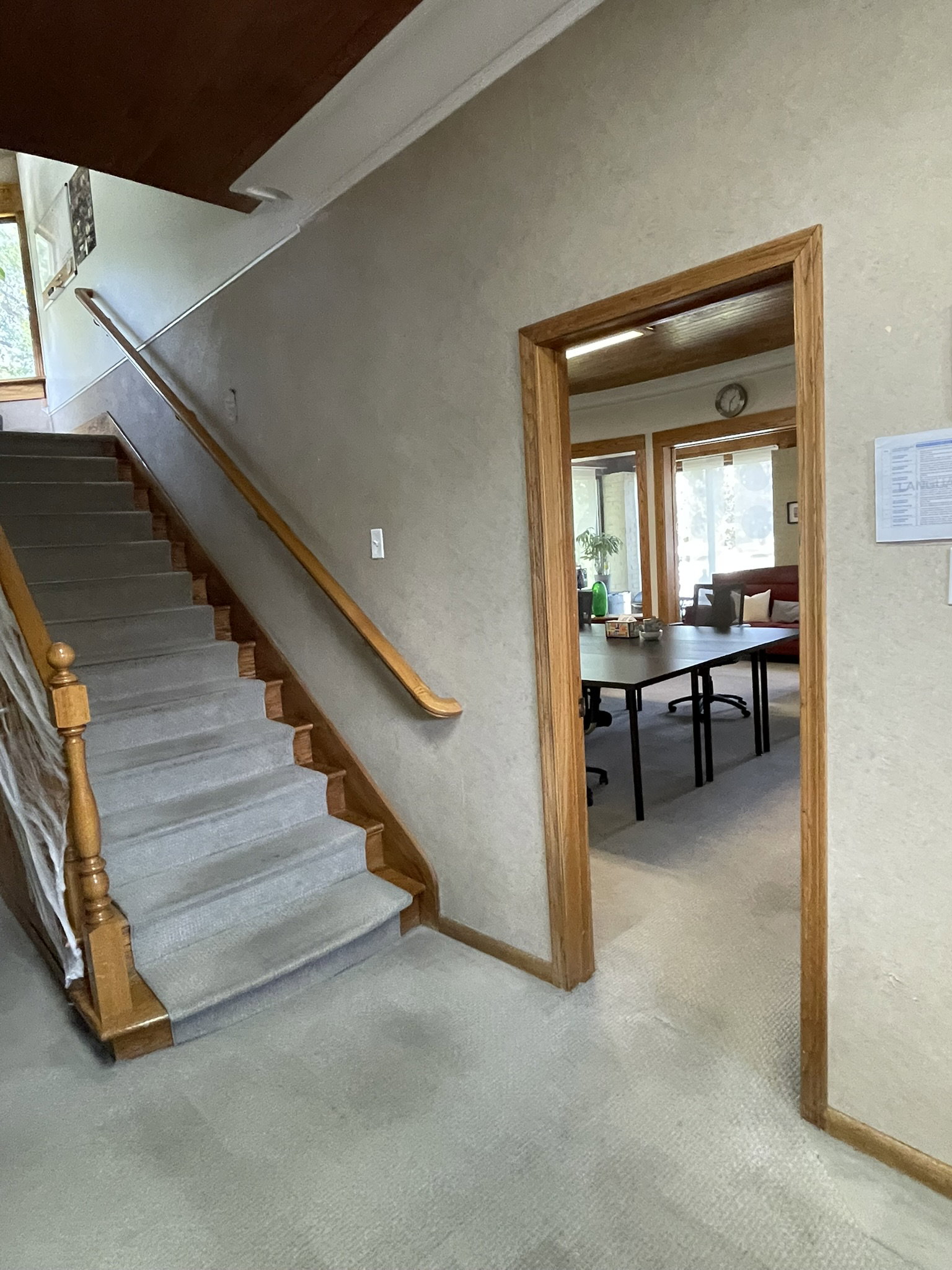 Stairs with a textured wall, crown molding, and carpet flooring