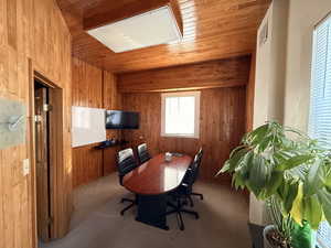 Home office with wood walls, carpet, and wooden ceiling