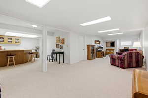Living room with light colored carpet and a dry bar