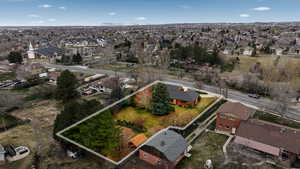 Aerial view of property and surrounding area featuring nearby suburban area