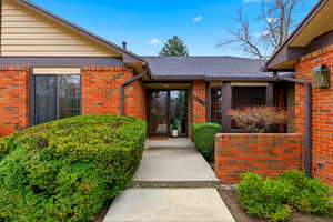 Property entrance with brick siding and roof with shingles