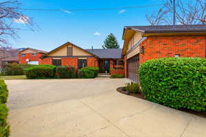 View of front of house featuring brick siding, concrete driveway, and a garage