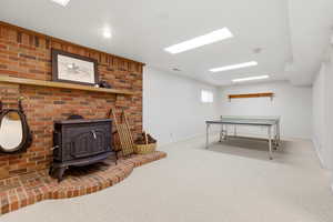 Playroom with a wood stove and light carpet