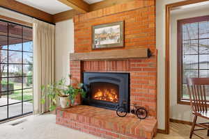Detailed view of carpet flooring and a brick fireplace