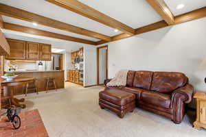 Living room with recessed lighting, light colored carpet, and beam ceiling