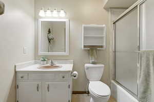Full bath featuring vanity and shower / bath combination with glass door