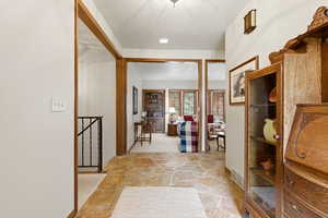 Hallway featuring baseboards and stone flooring