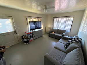 Living area featuring radiator, ceiling fan, and a textured ceiling