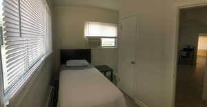 Bedroom with baseboard heating and cooling unit