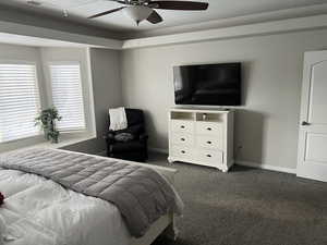 Bedroom featuring dark carpet and a ceiling fan