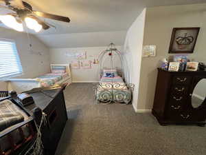 Bedroom with dark carpet and a ceiling fan