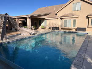 Swimming pool with a water slide and a patio