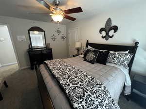 Bedroom with dark carpet and a ceiling fan