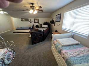 Bedroom featuring vaulted ceiling, carpet flooring, and a ceiling fan