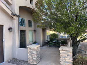 Doorway to property featuring stucco siding and a patio area
