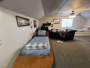Carpeted bedroom with vaulted ceiling and a ceiling fan
