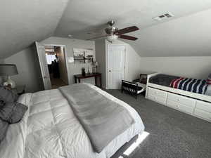 Bedroom featuring dark colored carpet, a textured ceiling, and ceiling fan