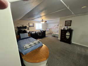 Carpeted bedroom with ceiling fan and baseboards