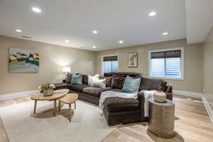 Living room featuring light wood finished floors, recessed lighting, and healthy amount of natural light