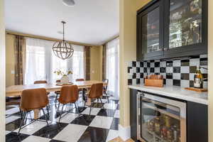 Dining space featuring beverage cooler, a chandelier, and healthy amount of natural light