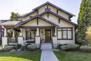 Craftsman house featuring covered porch and a front lawn