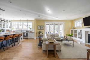 Living room with light wood-style flooring and a fireplace with flush hearth