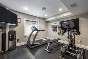 Exercise room featuring dark flooring and recessed lighting