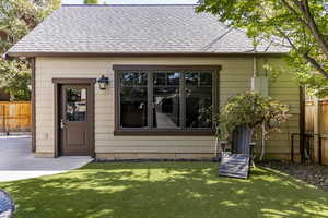 Doorway to property featuring roof with shingles