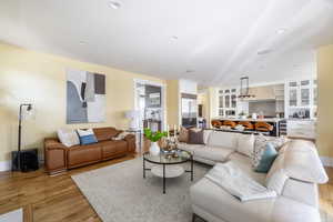 Living room with light wood-style flooring and recessed lighting