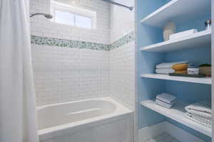 Bathroom featuring shower / bath combination with curtain