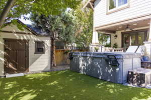 View of yard featuring a ceiling fan, a shed, and a patio