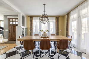 Dining room featuring decorative columns, hanging lights, and light wood-style flooring