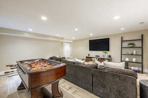 Rec room with light wood-type flooring and recessed lighting