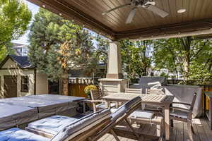 View of patio with a hot tub, ceiling fan, an outdoor structure, outdoor dining space, and area for grilling