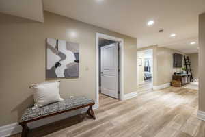 Hall featuring light wood-type flooring and recessed lighting