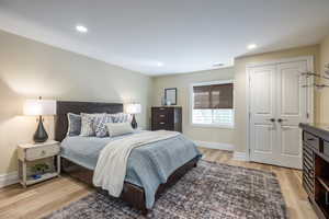 Bedroom featuring light wood-type flooring, a closet, and recessed lighting