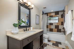 Full bath with vanity, tile patterned floors, and shower / bath combination with curtain
