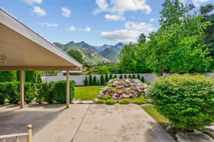 Fenced backyard featuring a mountain view and a patio area