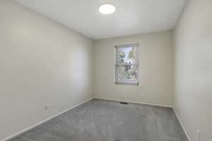 Empty room featuring carpet floors and baseboards