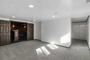 Unfurnished living room with carpet and recessed lighting