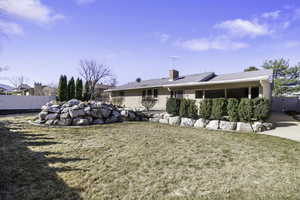 Rear view of house featuring a chimney and a gate