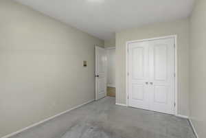 Unfurnished bedroom with a closet and carpet flooring