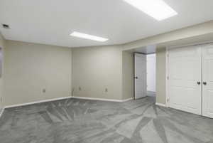 Finished below grade area with light colored carpet and baseboards