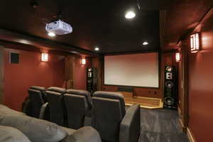Home theater room with dark colored carpet and recessed lighting